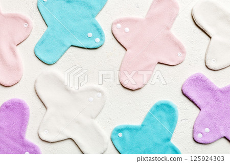 Eco-friendly reusable fabric women's pads. set of colorful bright reusable menstrual pads. zero waste woman periods concept top view with copy space Eco-friendly reusable fabric women's pads. set of colorful bright reusable menstrual pads. zero waste woman periods concept top view with copy space 125924303