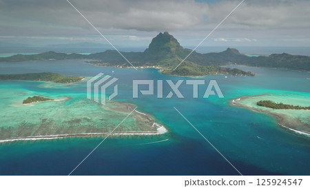 Stunning aerial view of Bora Bora volcanic island and turquoise lagoon. Coral reefs and small islets motus in French Polynesia. Popular travel destination, remote wild paradise, exotic summer travel 125924547
