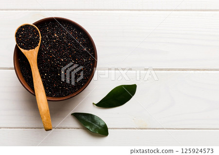 quinoa seeds in bowl and spoon on colored background. Healthy kinwa in small bowl. Healthy superfood 125924573