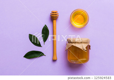 Honey jar with wooden honey dipper on white background top view with copy space. Delicious honey bottle 125924583