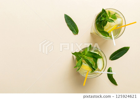 Caipirinha, Mojito cocktail, vodka or soda drink with lime, mint and straw on table background. Refreshing beverage with mint and lime in glass top view flat lay 125924621