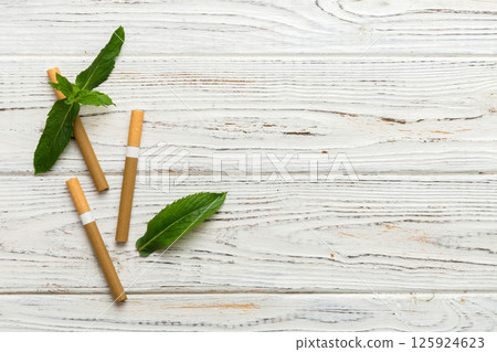 Menthol cigarettes and fresh mint leaves on colored background, Many cigarettes stacked together top view flat lay 125924623