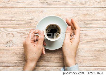 Minimalistic style woman hand holding a cup of coffee on Colored background. Flat lay, top view cappuccino cup. Empty place for text, copy space. Coffee addiction. Top view, flat lay Minimalistic style woman hand holding a cup of coffee on Colored background. Flat lay, top view cappuccino cup. Empty place for text, copy space. Coffee addiction. Top view, flat lay 125924631
