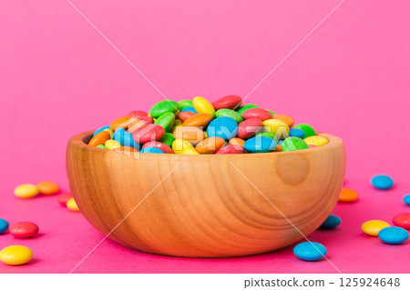 Multicolored candies in a bowl on a colored background. birthday and holiday concept. Top view with copy space 125924648