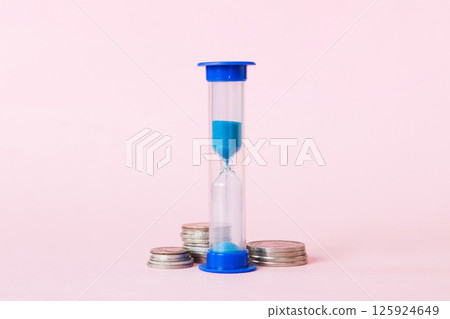 Deadline and time is money concept with hourglass and US coins currency. sand clock time for saving concept 125924649