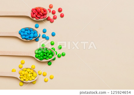 delicious colorful sweet candies on spoon on colored background . Confectionery decor top view with copy space 125924654
