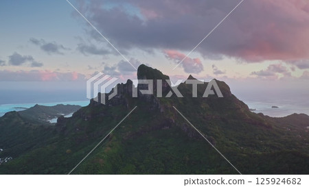 Aerial drone majestic mount Otemanu, Bora Bora island in French Polynesia. Volcanic mountain peaks under vibrant colorful sunset sky clouds. Popular travel destination, remote wild paradise 125924682