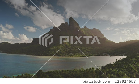 Stunning drone footage highlights majestic mount Otemanu rising over the turquoise waters and lush greenery of Bora Bora, capturing nature's breathtaking beauty. Travel tropical vacation concept 125924698