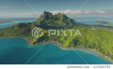 Breathtaking drone footage revealing the stunning beauty of Bora Bora, featuring iconic mount Otemanu, crystal-clear turquoise waters, vibrant coral reefs, and lush vegetation 125924703
