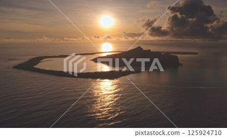 Golden sunrise illuminates the silhouette of mount Otemanu on Bora Bora island in French Polynesia, reflecting on the calm waters of the pacific ocean with dramatic clouds adding a touch of majesty Golden sunrise illuminates the silhouette of mount Otemanu on Bora Bora island in French Polynesia, reflecting on the calm waters of the pacific ocean with dramatic clouds adding a touch of majesty 125924710