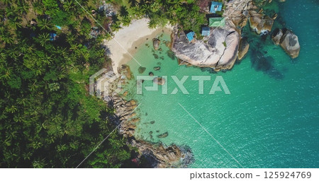 Aerial view of a tropical beach landscape with lush greenery, white sandy shore, turquoise water waves surrounded by rocks. Nature vacation concept. Thailand, Koh Phangan Island, Haad Thong Reng Beach 125924769