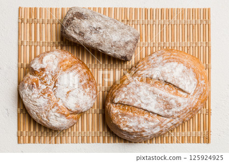 Assortment of freshly baked bread with napkin on rustic table top view. Healthy unleavened bread. French bread 125924925