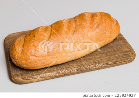 Freshly baked bread on cutting board against white wooden background. perspective view bread with copy space Freshly baked bread on cutting board against white wooden background. perspective view bread with copy space 125924927