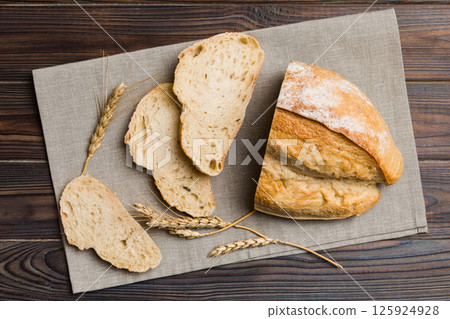 Freshly baked bread slices on napkin against natural background. top view Sliced bread Freshly baked bread slices on napkin against natural background. top view Sliced bread 125924928