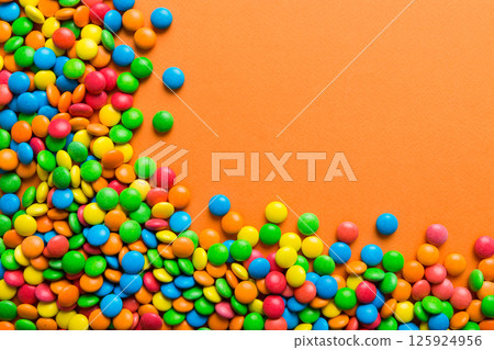 Mixed collection of colorful candy, on colored background. Flat lay, top view. frame of colorful chocolate coated candy Mixed collection of colorful candy, on colored background. Flat lay, top view. frame of colorful chocolate coated candy 125924956
