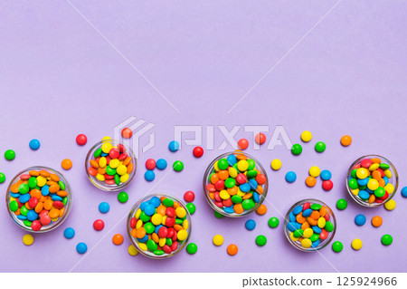different colored round candy in bowl and jars. Top view of large variety sweets and candies with copy space 125924966