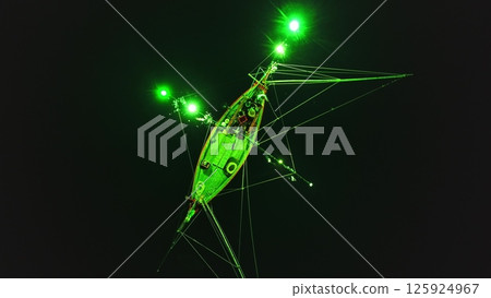 Low angle night view of a squid fishing boat using green lights to attract its prey, creating a surreal atmosphere in the darkness off the coast of Koh Phangan, Thailand 125924967