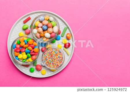 different colored round candy in bowl and jars. Top view of large variety sweets and candies with copy space 125924972