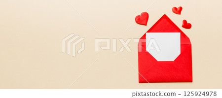Red paper envelope with empty white card and heart on colored background. top view valentines day concept Red paper envelope with empty white card and heart on colored background. top view valentines day concept 125924978
