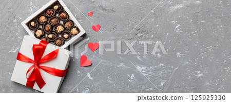 Delicious chocolate pralines in red box for Valentine's Day. Heart shaped box of chocolates top view with copy space 125925330