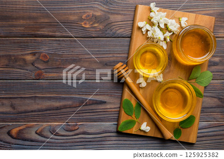 honey jar with acacia flowers and leaves. fresh honey top view flat lay honey jar with acacia flowers and leaves. fresh honey top view flat lay 125925382