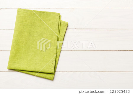 top view with green kitchen napkin isolated on table background. Folded cloth for mockup with copy space, Flat lay. Minimal style top view with green kitchen napkin isolated on table background. Folded cloth for mockup with copy space, Flat lay. Minimal style 125925423