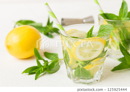 Mojito cocktail. Refreshing mojito cocktail with lime, lemon and mint in a tall glass with a stick 125925444