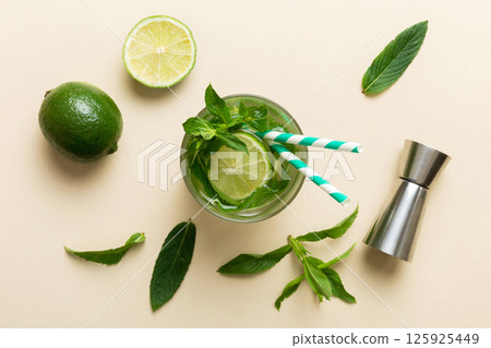 Caipirinha, Mojito cocktail, vodka or soda drink with lime, mint and straw on table background. Refreshing beverage with mint and lime in glass top view flat lay Caipirinha, Mojito cocktail, vodka or soda drink with lime, mint and straw on table background. Refreshing beverage with mint and lime in glass top view flat lay 125925449