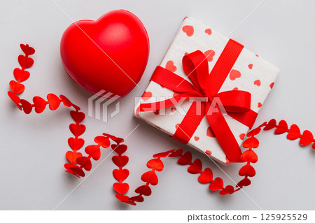gift box with red bow and red heart on colored background . Top view. Flat lay 125925529