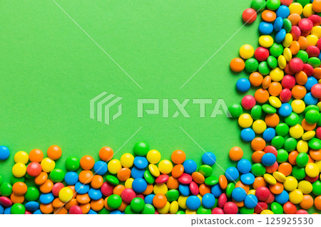 Mixed collection of colorful candy, on colored background. Flat lay, top view. frame of colorful chocolate coated candy Mixed collection of colorful candy, on colored background. Flat lay, top view. frame of colorful chocolate coated candy 125925530