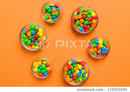 different colored round candy in bowl and jars. Top view of large variety sweets and candies with copy space 125925699