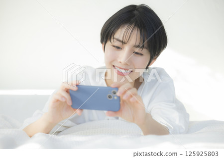 一個女人在床上放鬆 一個女人在床上放鬆 125925803