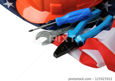 Labor Day features tools and a hard hat on an American flag, isolated on white Labor Day features tools and a hard hat on an American flag, isolated on white 125925922