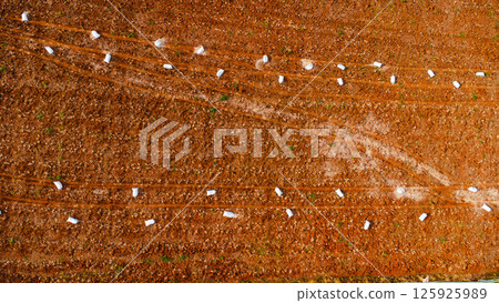 Aerial view of tractor plowing in spring. Tractor drives preparing beds for planting seedlings in cultivated soil. Aerial view of tractor plowing in spring. Tractor drives preparing beds for planting seedlings in cultivated soil. 125925989