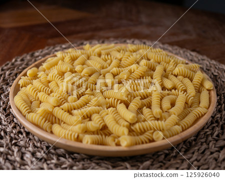Raw Fusilli Spiral spaghetti pasta pattern background. Raw Fusilli Spiral spaghetti pasta pattern background. 125926040