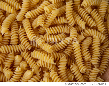 Raw Fusilli Spiral spaghetti pasta pattern background. Raw Fusilli Spiral spaghetti pasta pattern background. 125926041