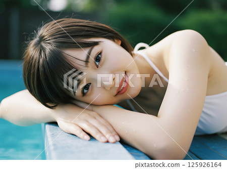 Young woman relaxing by the pool 125926164