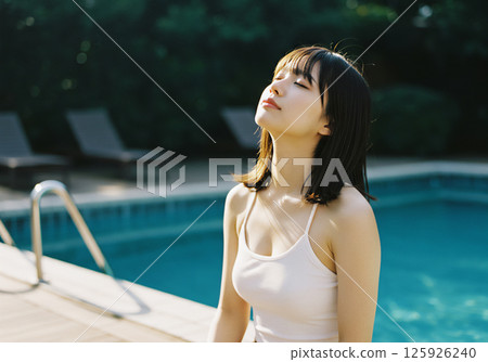 Young woman relaxing by the pool 125926240