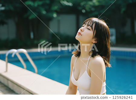 Young woman relaxing by the pool 125926241