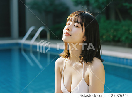 Young woman relaxing by the pool 125926244