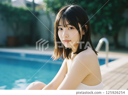 Young woman relaxing by the pool 125926254