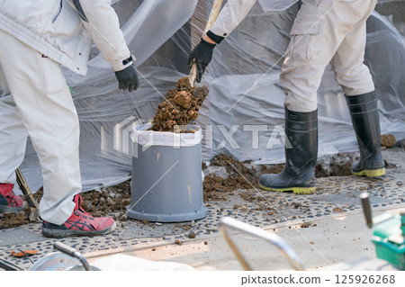 污水處理施工:土木工程工人用土填滿沙袋 污水處理施工:土木工程工人用土填滿沙袋 125926268