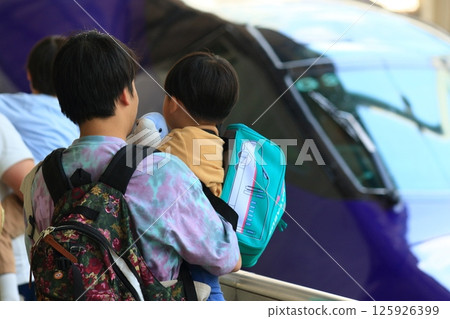 A father holding his child who loves bullet trains A father holding his child who loves bullet trains 125926399