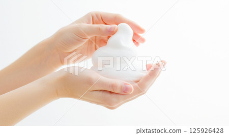 Image of a woman lathering up a thick, white facial cleanser foam in her hands Image of a woman lathering up a thick, white facial cleanser foam in her hands 125926428