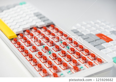 Red mechanical keyboard switches exposed, showing hot-swappable design for customization Red mechanical keyboard switches exposed, showing hot-swappable design for customization 125926682