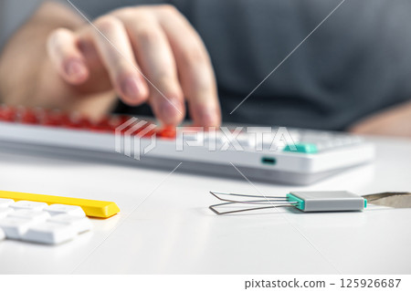 Hands using keycap puller near mechanical keyboard for customization or modification Hands using keycap puller near mechanical keyboard for customization or modification 125926687