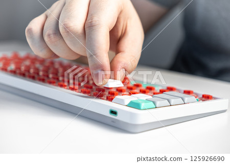Hand installing white keycap onto red mechanical switch during custom keyboard building process Hand installing white keycap onto red mechanical switch during custom keyboard building process 125926690