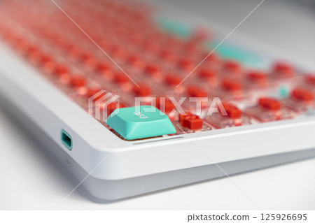 Close-up of custom mechanical keyboard with teal escape key and exposed red switch layout Close-up of custom mechanical keyboard with teal escape key and exposed red switch layout 125926695