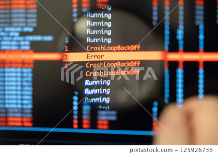 Man's hand holds magnifying glass over screen showing CrashLoopBackOff and Error messages, symbolizing focused debugging work 125926736