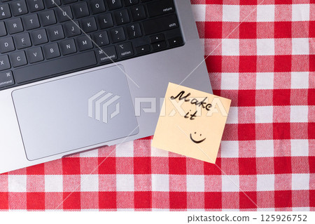 Sticky note with encouraging message Make it smiling placed on laptop promoting motivation and success 125926752